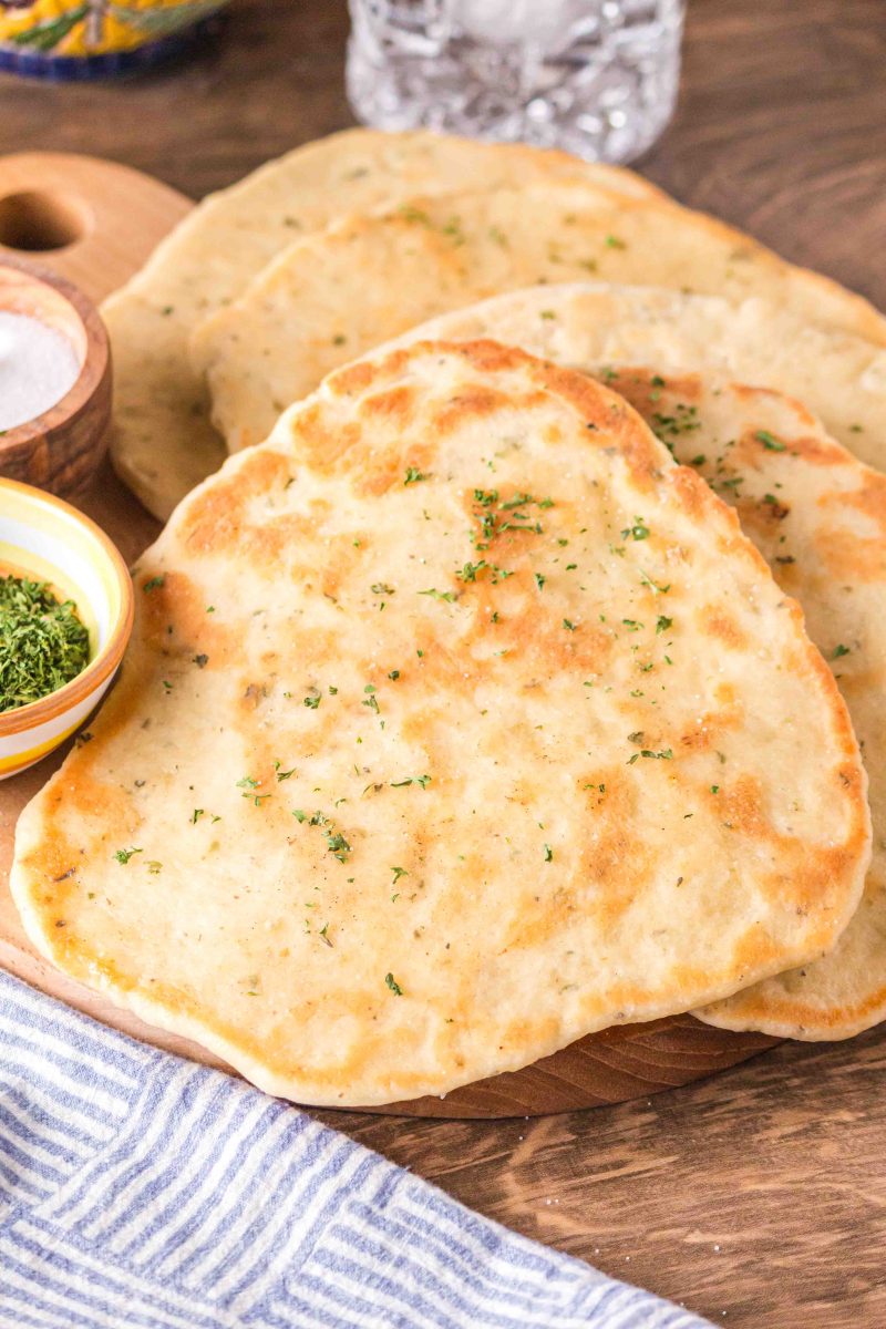 Three flatbreads on a cutting board ready to eat.