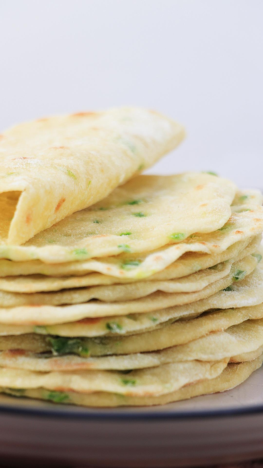 Stack of jalapeno tortillas on a plate, side view to show thickness and flexibility.