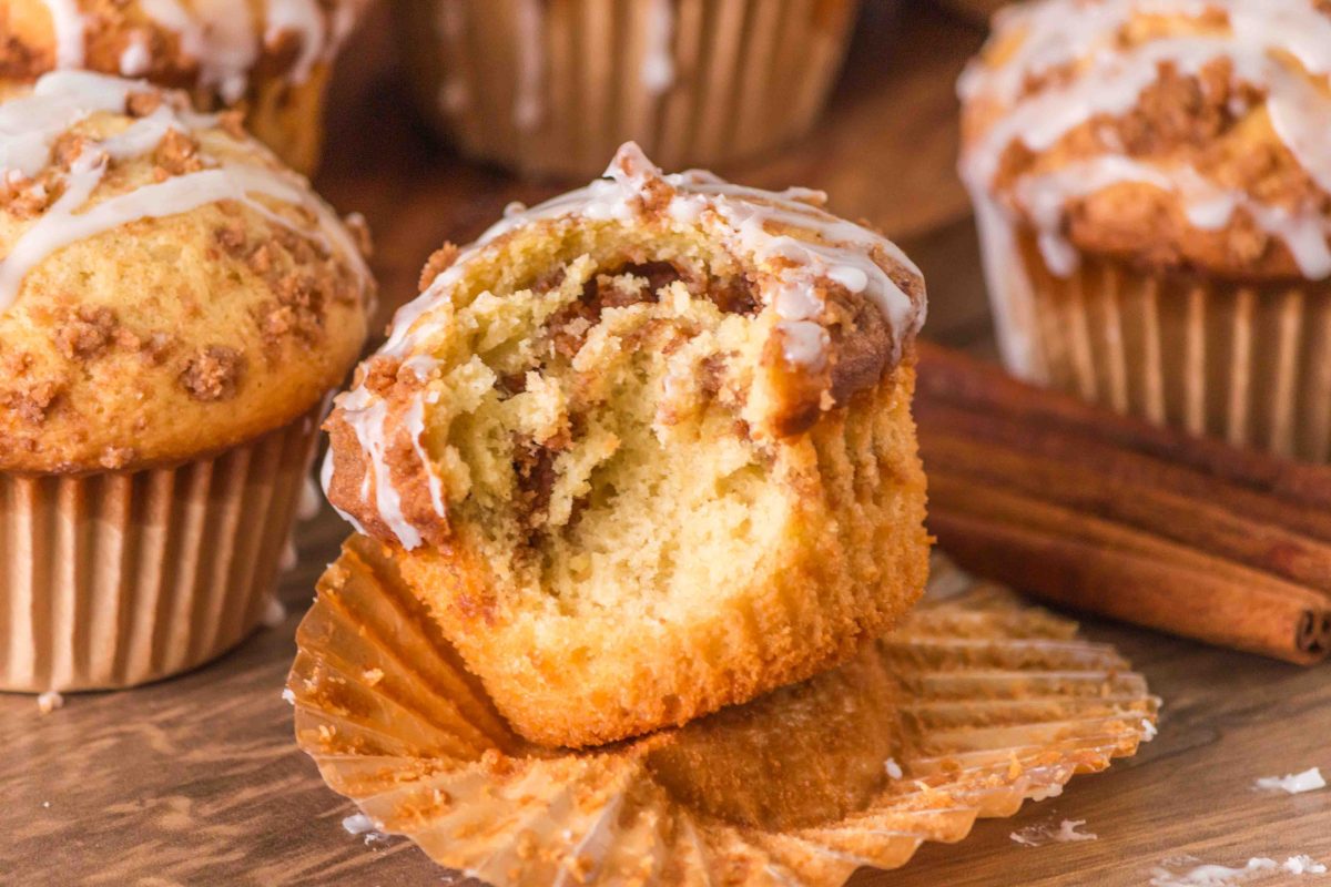 Cinnamon Roll Muffins, close up with one that has been bitten out of to reveal the tender inside.