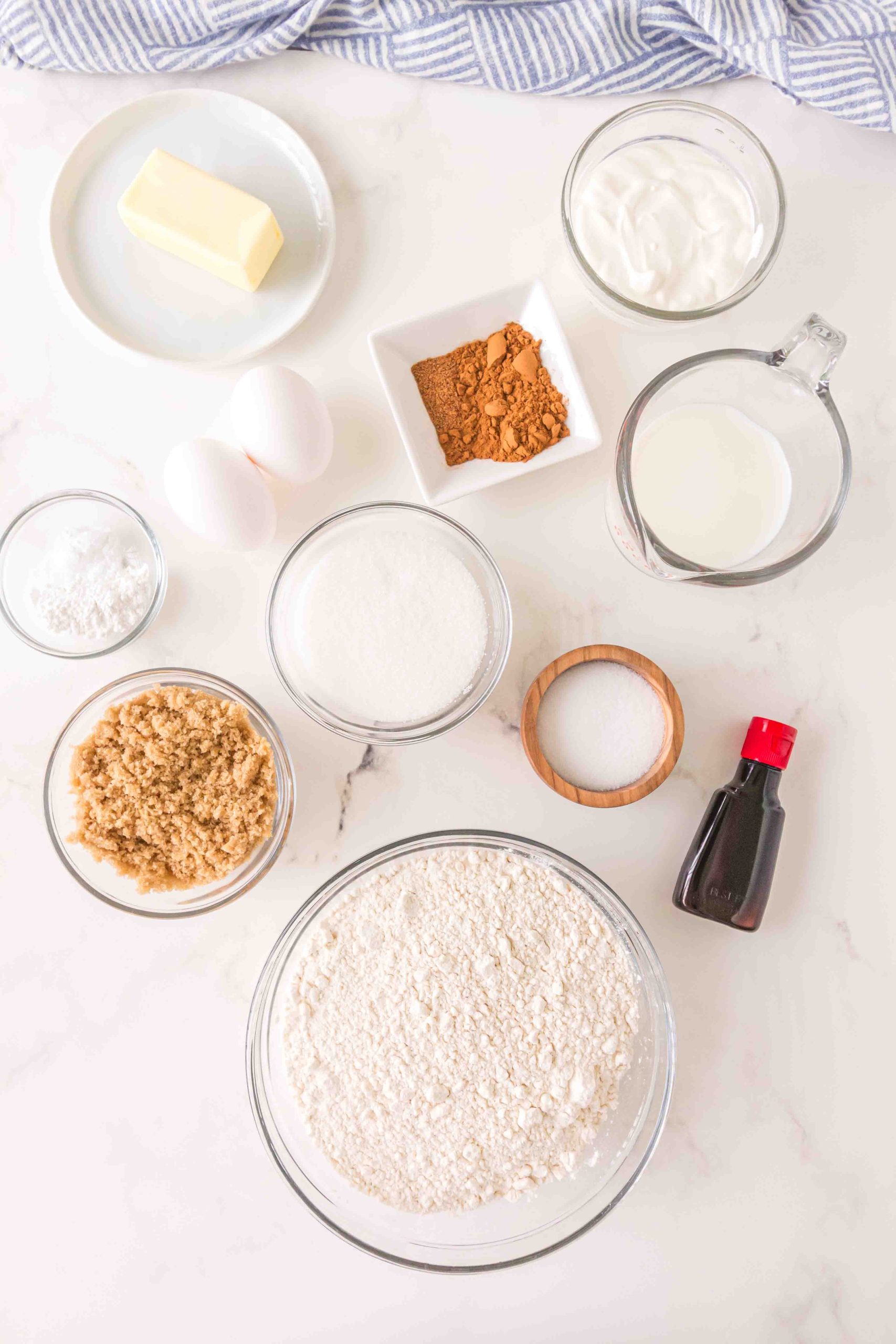 Ingredients for Cinnamon Roll Muffins: butter, sour cream, eggs, cinnamon, baking soda, milk, sugar, baking powder, salt, eggs, vanilla, milk, powdered sugar, nutmeg, cinnamon, brown sugar.