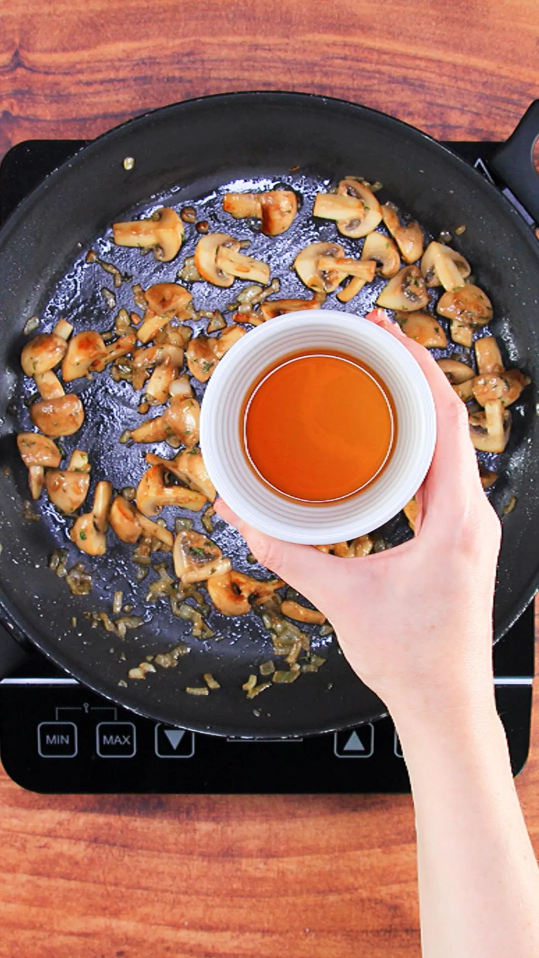 Adding dry sherry to the skillet with mushrooms and onions.