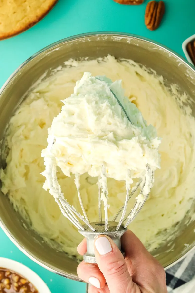 A mixer whisk attachment filled with a fluffy mix of butter and sugar - Hostess At Heart