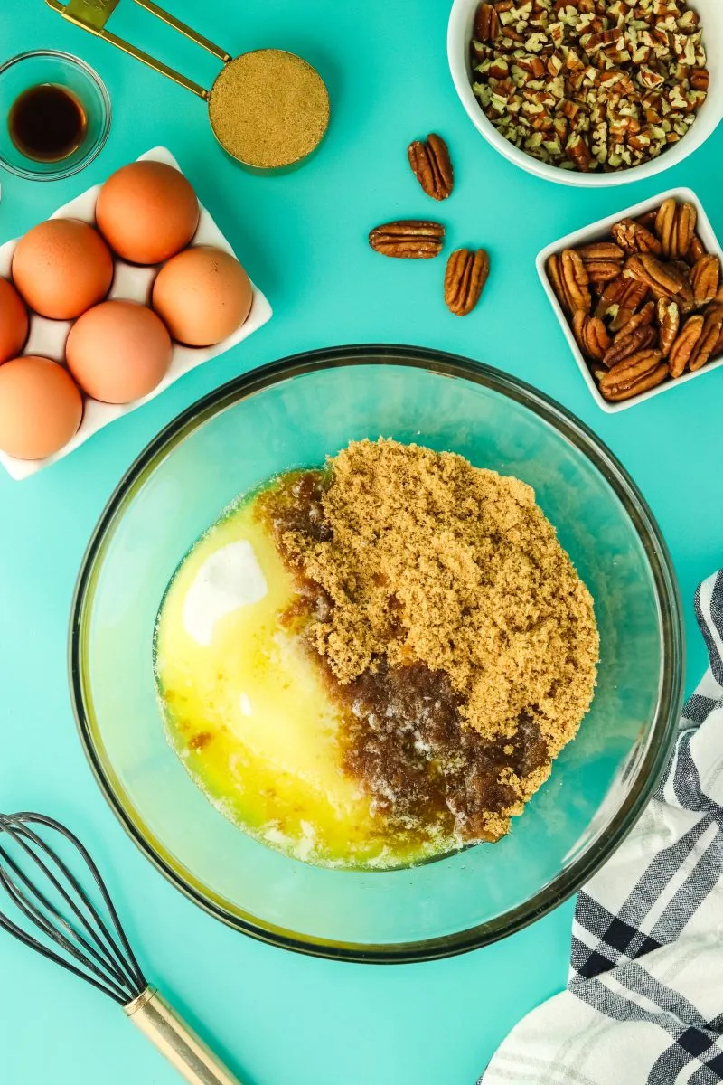 A mixing bowl filled with white sugar, brown sugar, and melted butter. Hostess At Heart