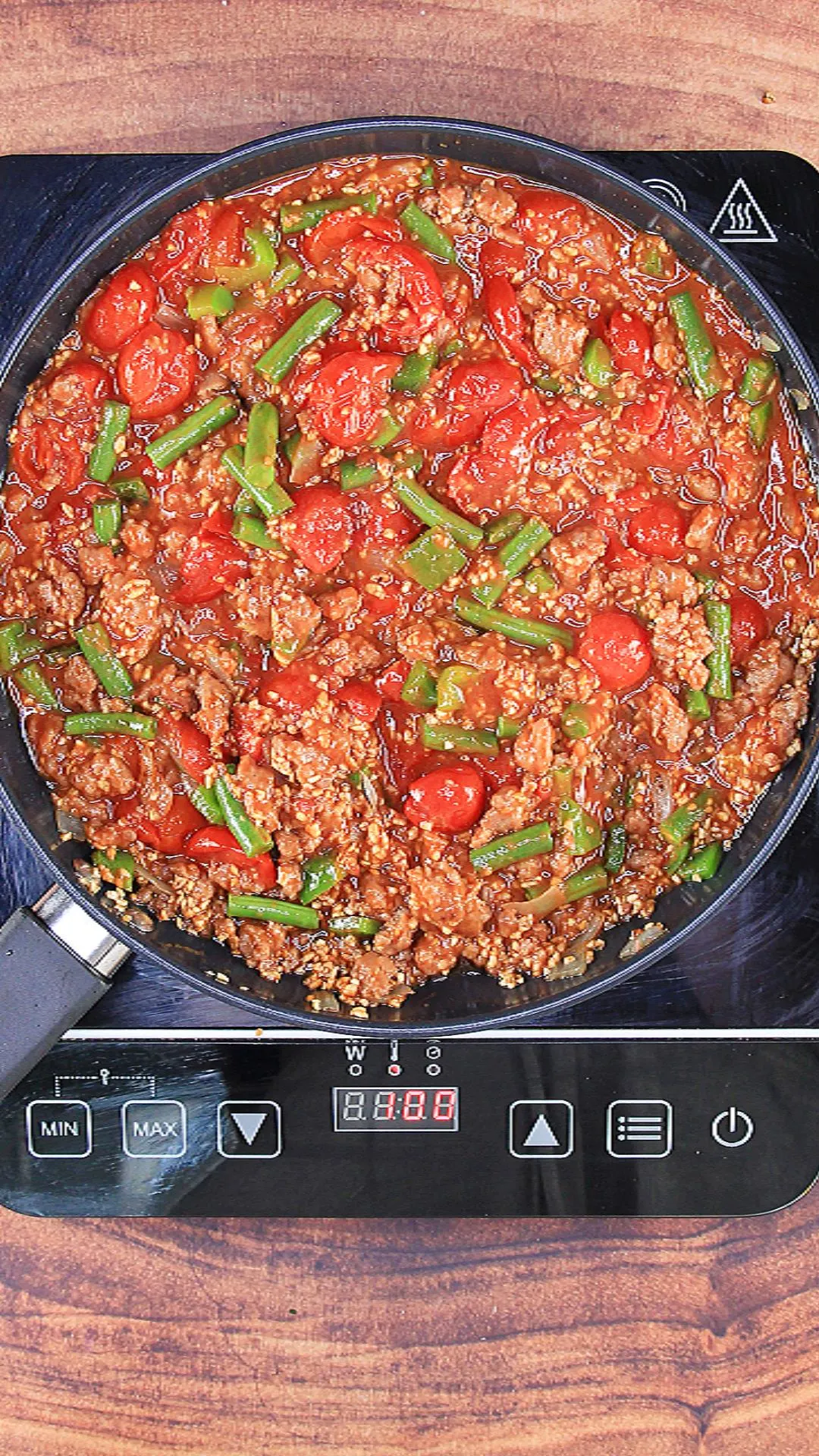 Simmered bulgar and sausage dish in a skillet.