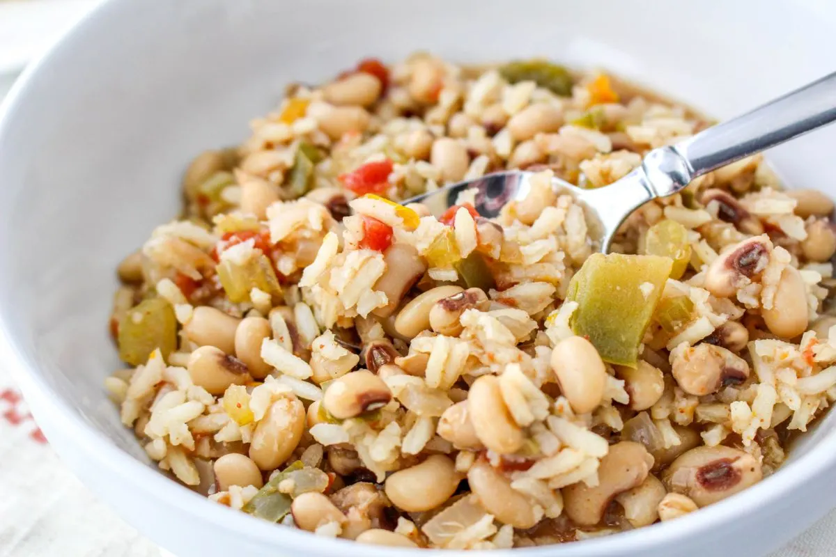 Closeup side view of a spoon filled with slow cooker black-eye peas and rice. Hostess At Heart