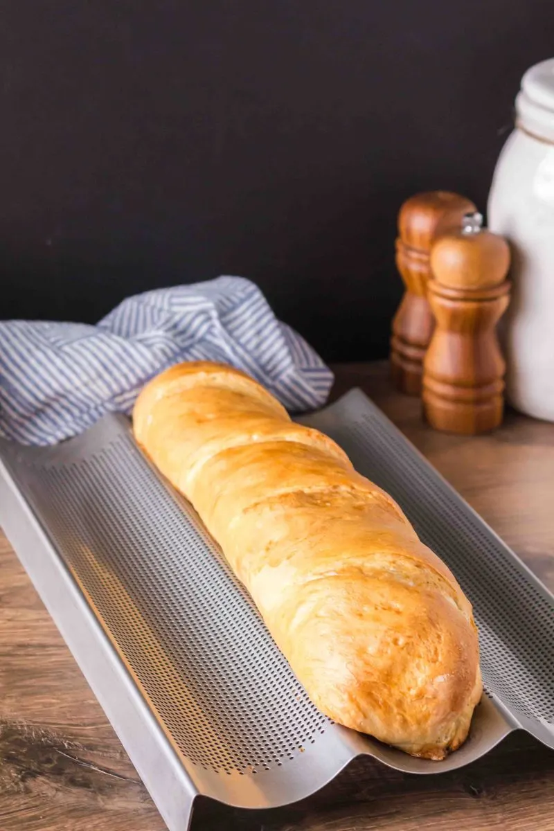 A loaf of baked bread on a French Baking Pan