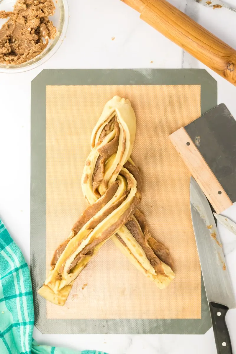 Two strands of cinnamon sugar filled dough being twisted together - Hostess At Heart