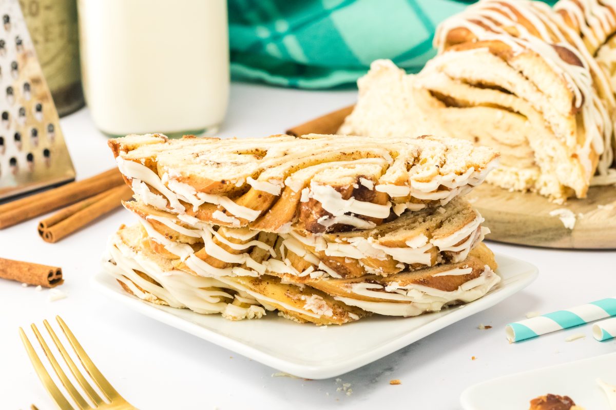 Front view of a stack of slices of cinnamon twist bread with the loaf in the background. Hostess At Heart.