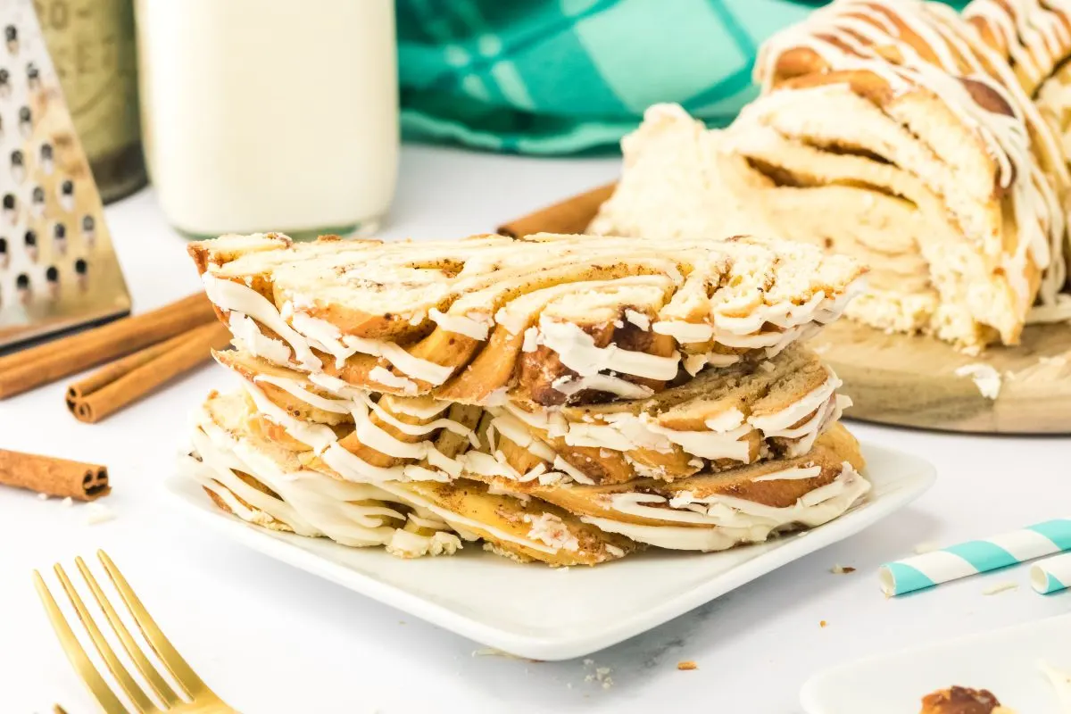 Front view of a stack of slices of cinnamon twist bread with the loaf in the background. Hostess At Heart.