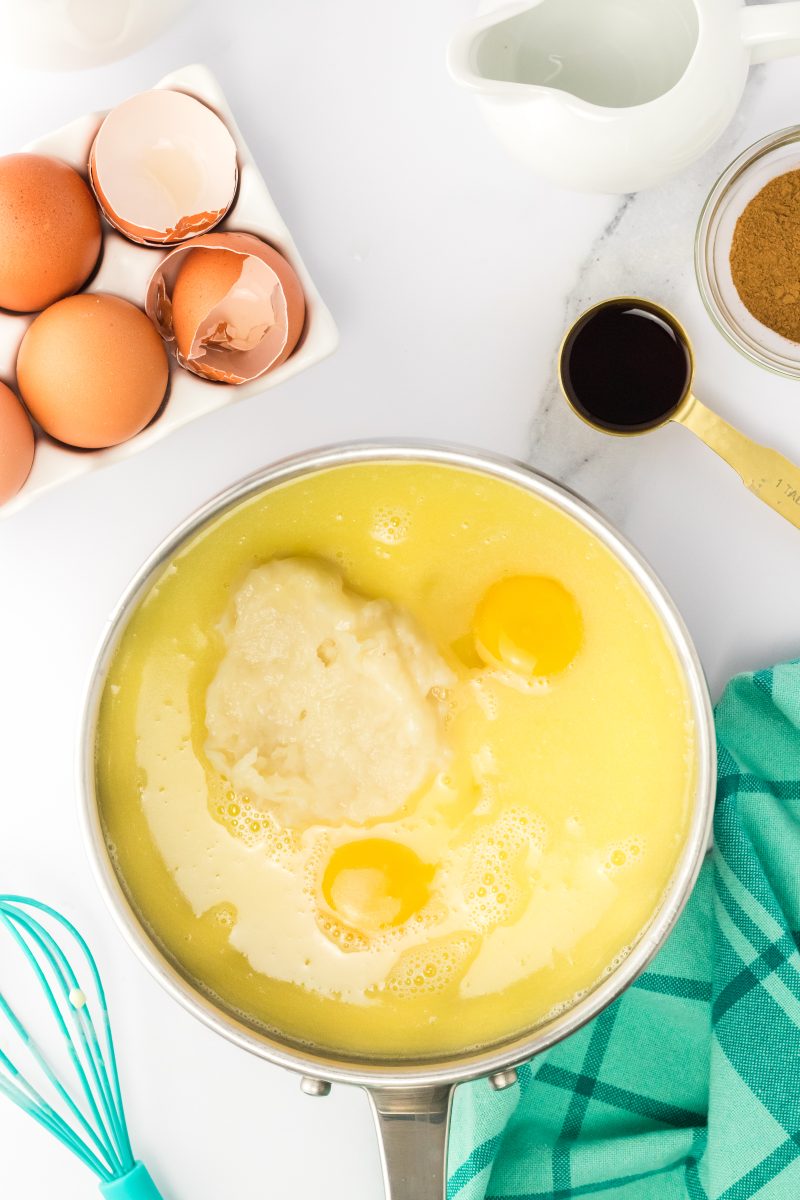 A saucepan filled with a butter mixture, cooked paste, and eggs.