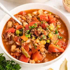 Angled view of hamburger vegetable soup loaded with chunks of tomatoes and veggies. Hostess At Heart