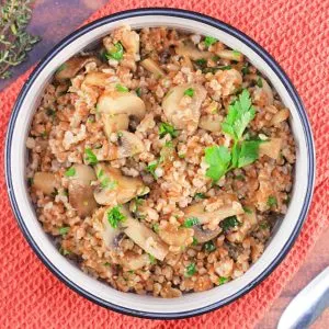 Top down view of a bowl filled with cooked farro with mushrooms - Hostess At Heart