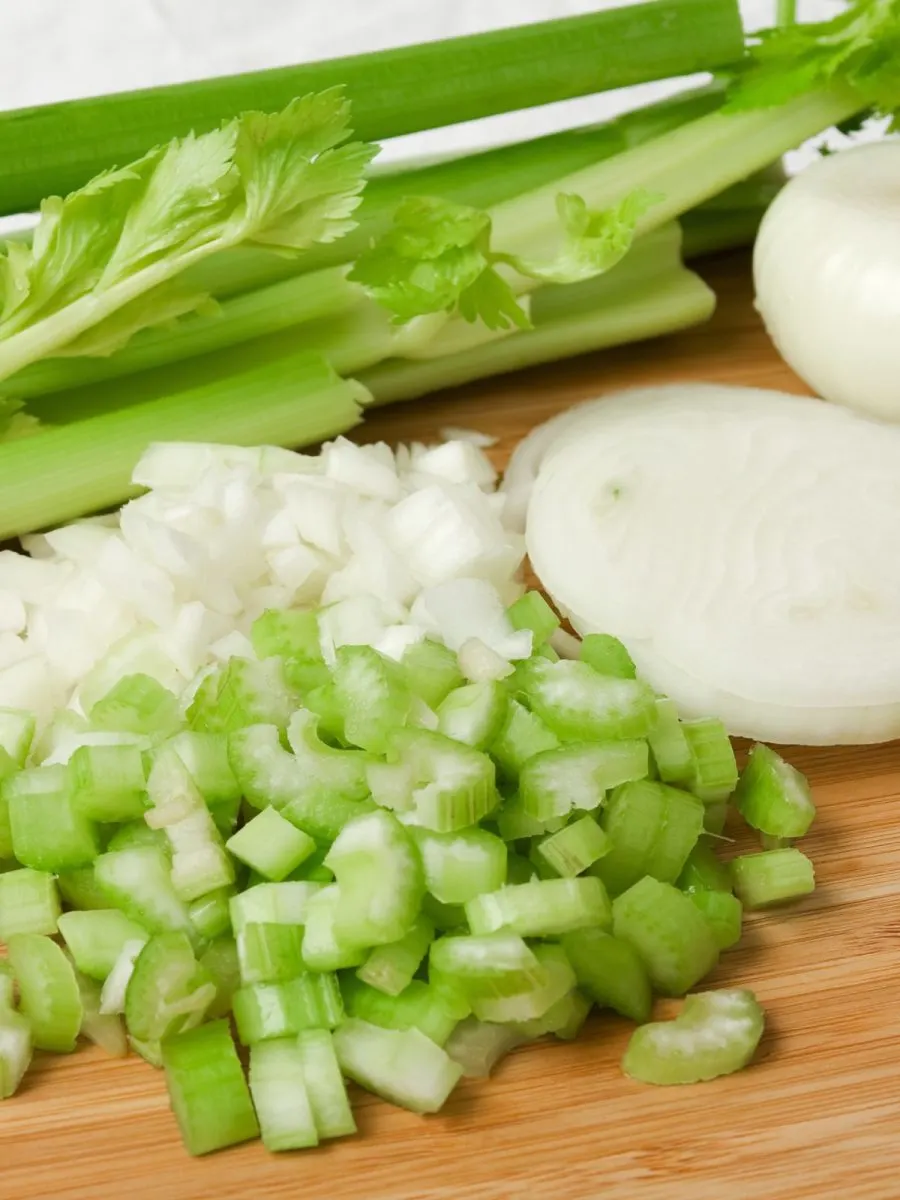 Chopped onion and celery on a cutting board - Hostess At Heart