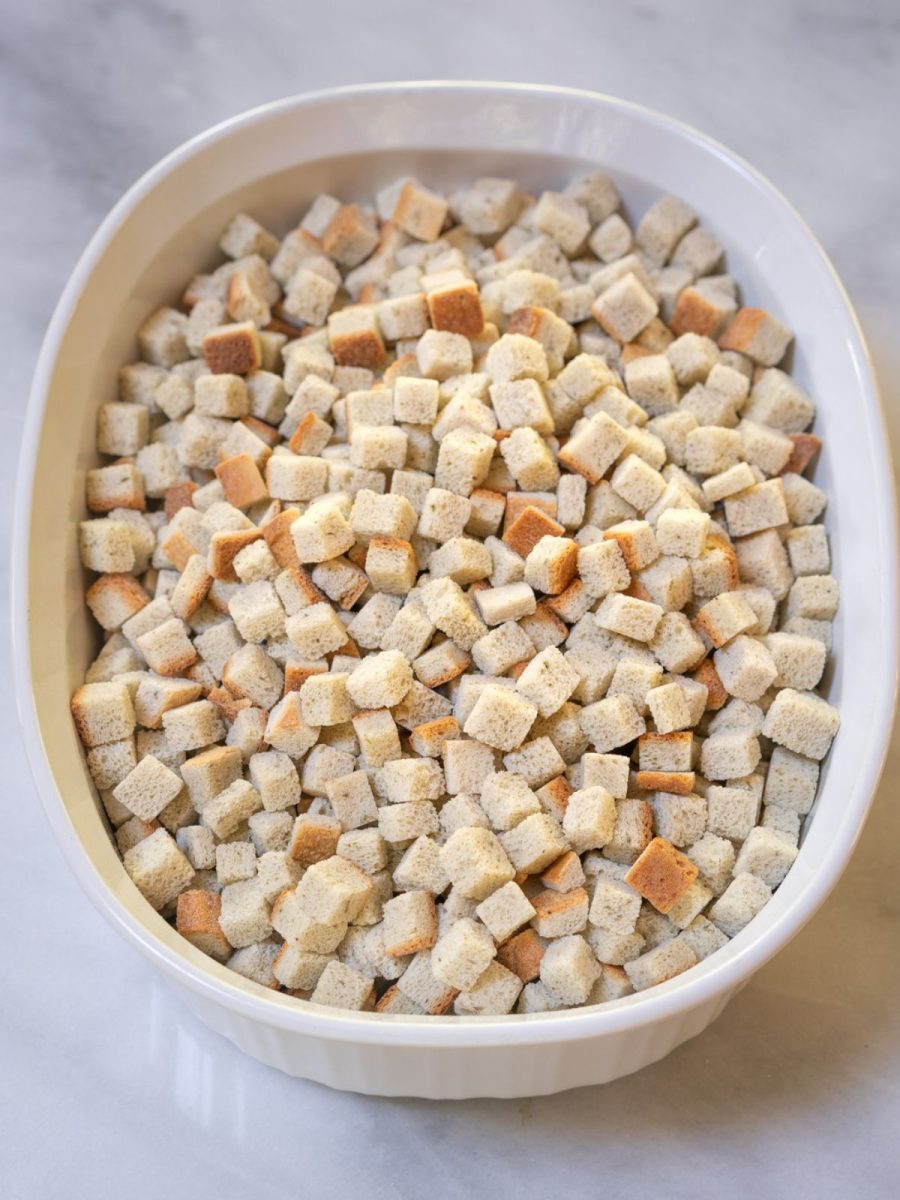 A casserole dish that's been greased and filled with bread cubes - Hostess At Heart