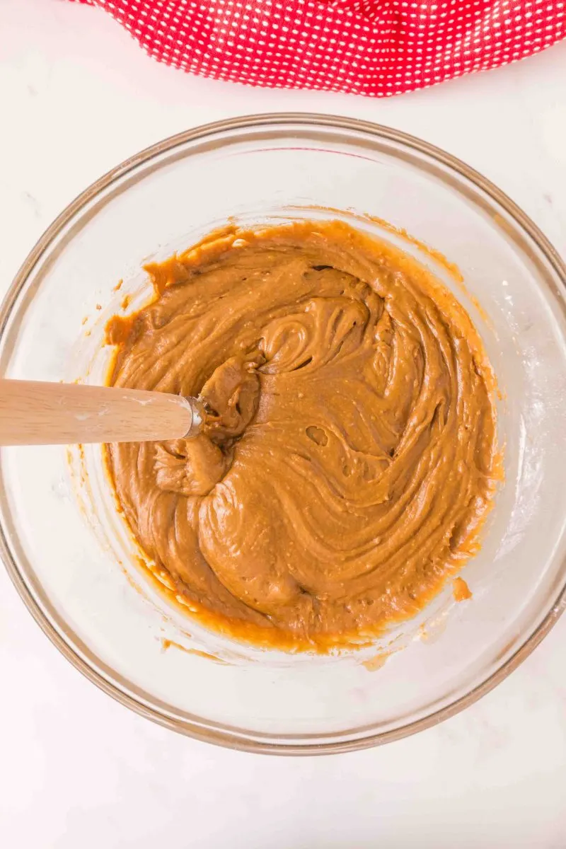 A mixing bowl containing smooth gingerbread muffin batter.