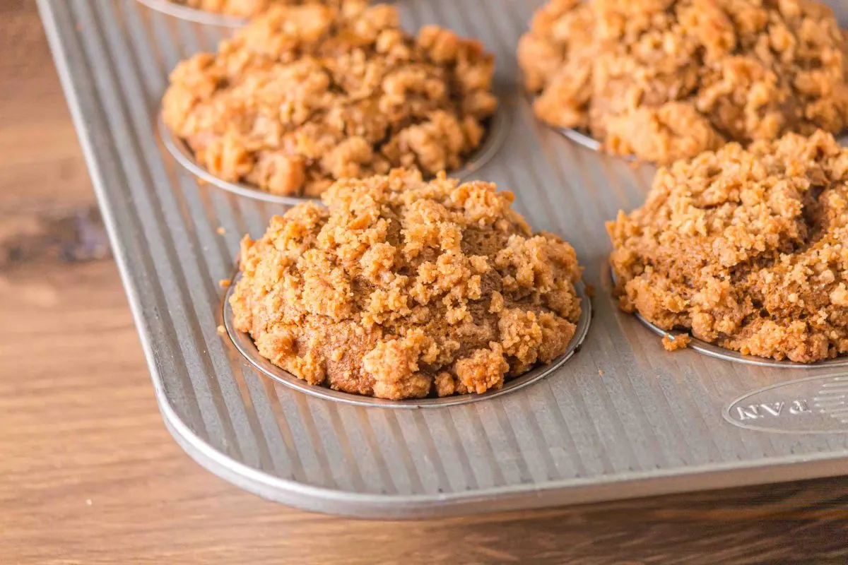 Close up of streusel topped gingerbread muffins in the baking pan.