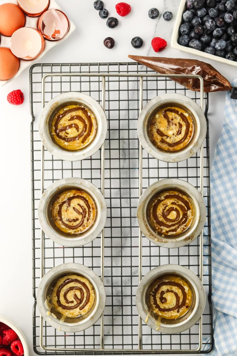 Popover pan filled with batter and topped with a swirl of cinnamon sugar filling - Hostess At Heart