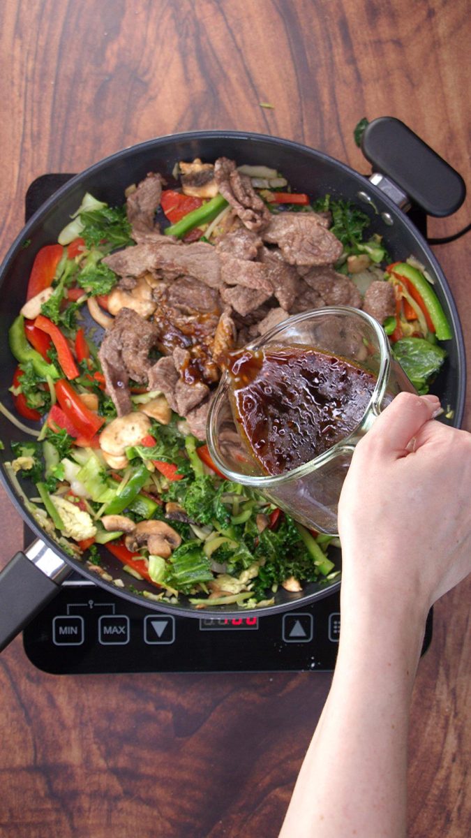 Asian sauce added to stir fried meat and veggies in a skillet - Hostess At Heart