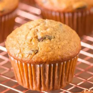 Sideview of a baked raisin oatmeal muffin sitting on a cooling rack - Hostess At Heart