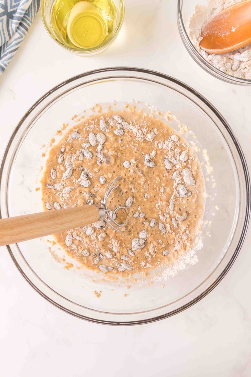 Dry ingredients being mixed into wet muffin batter in a mixing bowl - Hostess At Heart