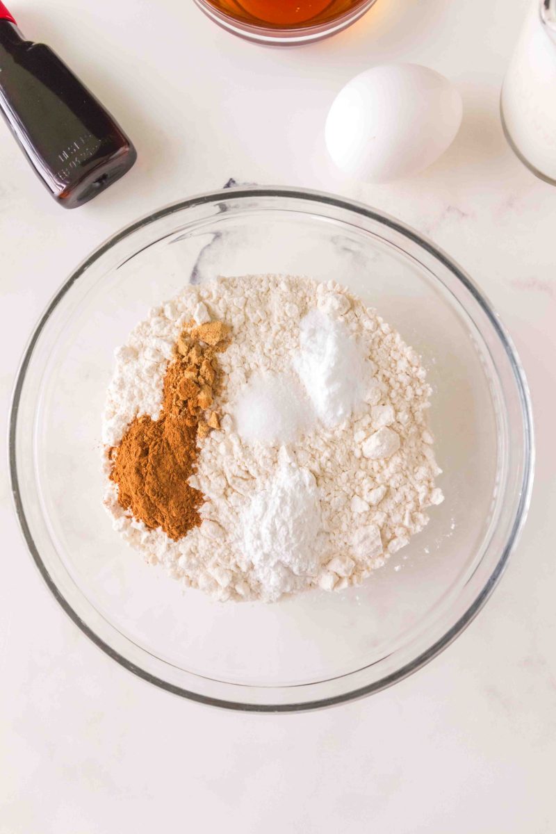 Dry ingredients in a mixing bowl; flour, salt, cinnamon, ginger, baking powder and baking soda used to make oatmeal raisin muffin recipe - Hostess At Heart