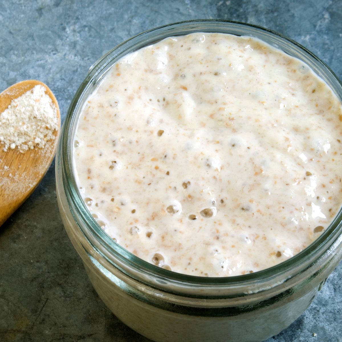 Top down view of a jar filled with active sourdough bread starter - Hostess At Heart