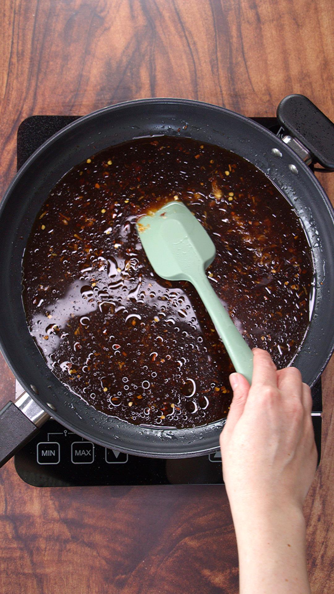 Cooking the stir fry sauce in a skillet over medium heat.