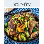 A angled top image for Pinterest of a beef stir-fry. Hostess At Heart