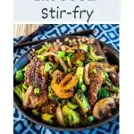 A angled top image for Pinterest of a beef stir-fry. Hostess At Heart