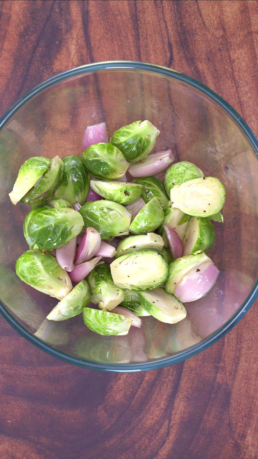 A bowl filled with sliced Brussels Sprouts and shallots.