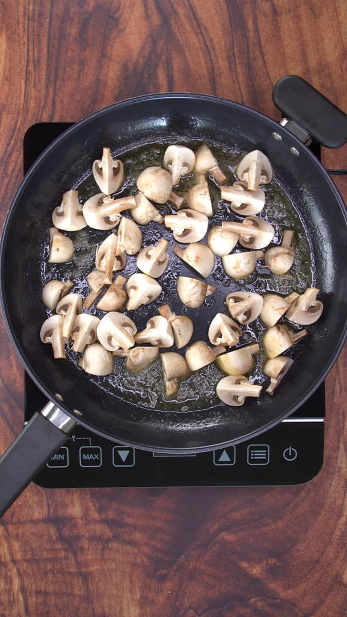 Raw quartered mushrooms in a skillet