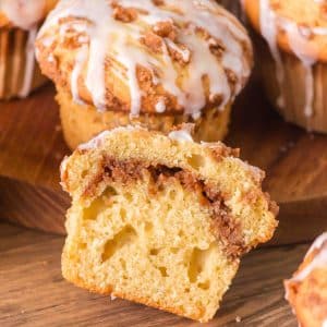 Top down view of a cinnamon swirl muffin with sour cream cut in half leaning against a whole muffin. Hostess At Heart