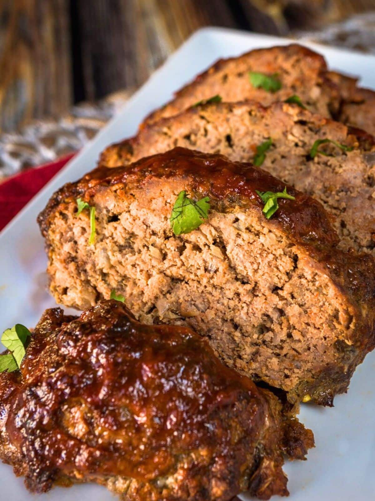 Front view of a baked and sliced meat loaf glazed with a sweet tangy sauce. Hostess At Heart