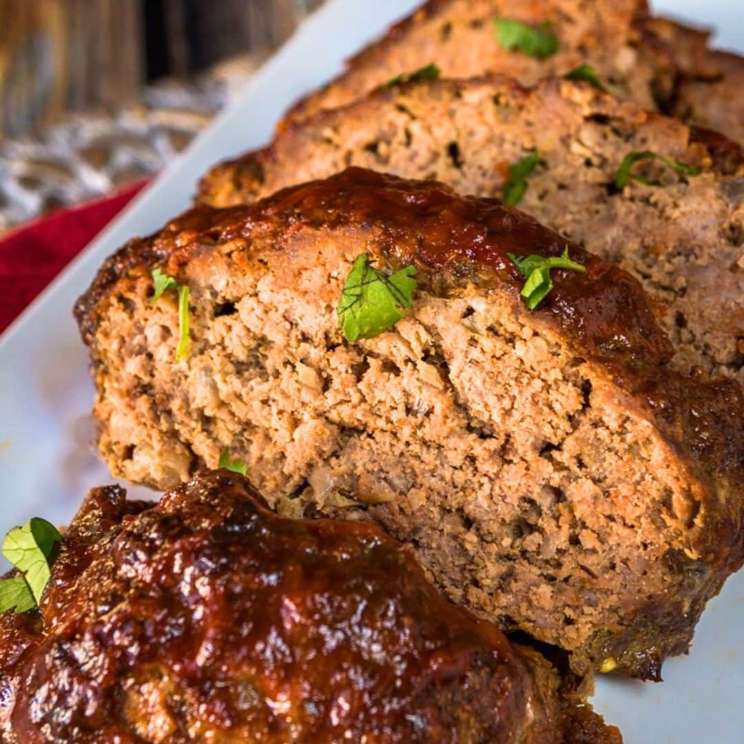 Front view of a sliced meatloaf topped with a sweet glaze - Hostess At Heart