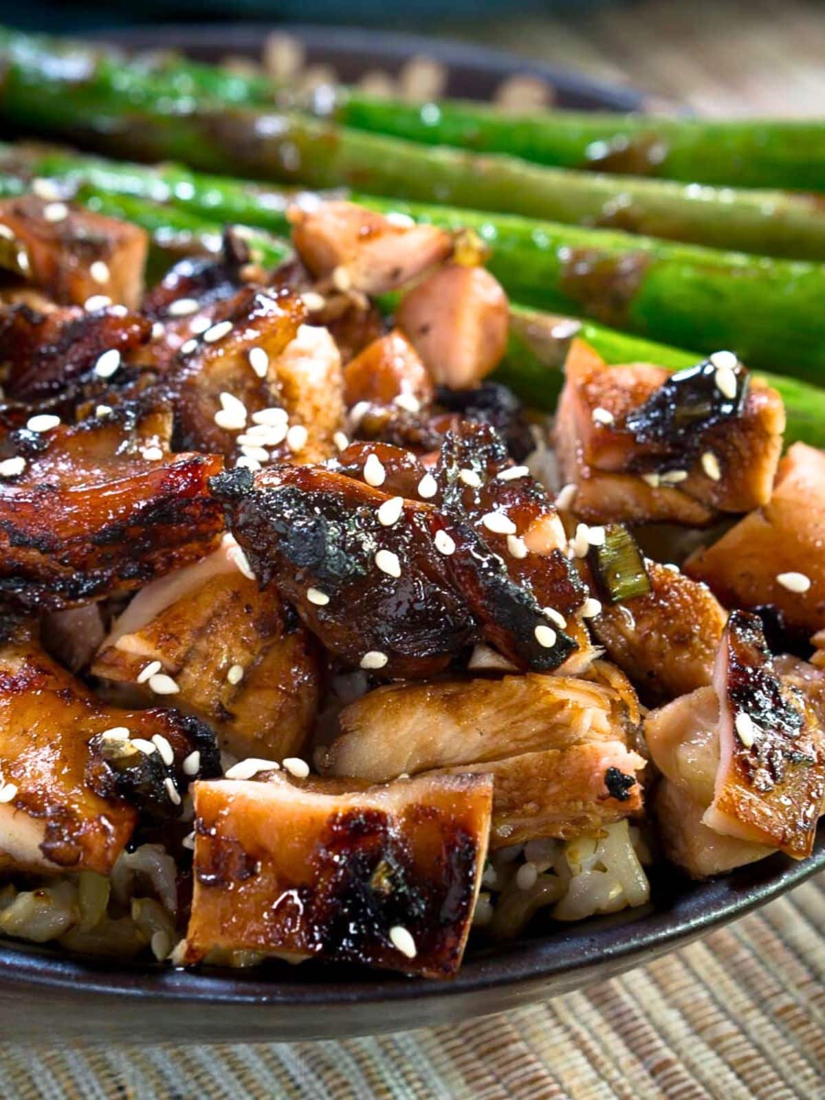 Sideview of grilled chicken with a teriyaki glaze garnished with sesame seeds - Hostess At Heart