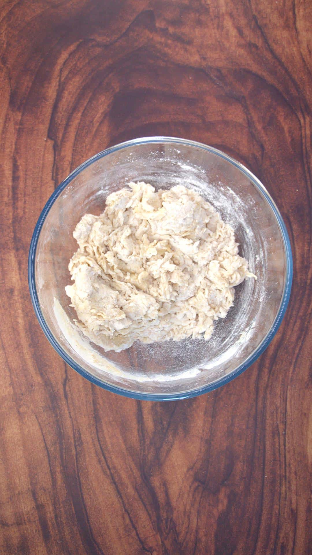 Soft, crumbly ball of dough in a mixing bowl.