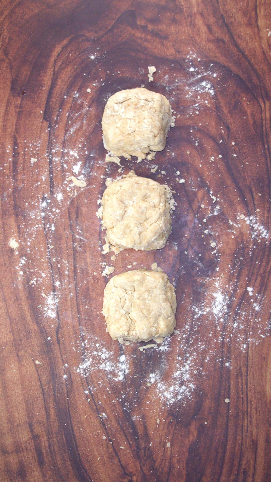 Cracker dough split into three equal parts and formed loosely into squares.