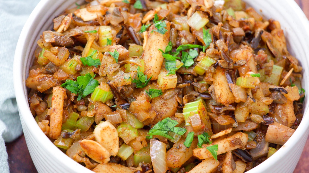 Closeup view of cooked five spice seasoned rice, cooked mushrooms, celery, and chestnuts in a bowl. Hostess At Heart