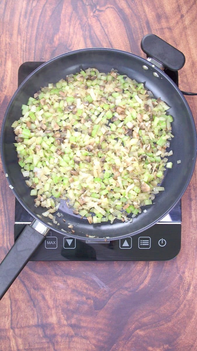 A skillet of simmering chopped onions, celery, mushrooms, and chestnuts. Hostess At Heart