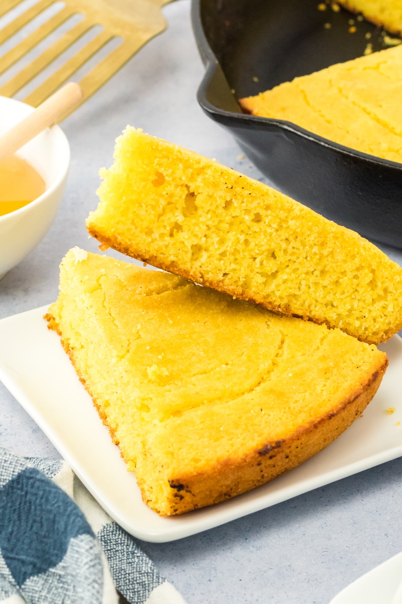Two wedges of cornbread stacked on each other - Hostess At Heart