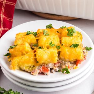 Angled view of a white plate topped with hamburger tater tot casserole - Hostess At Heart