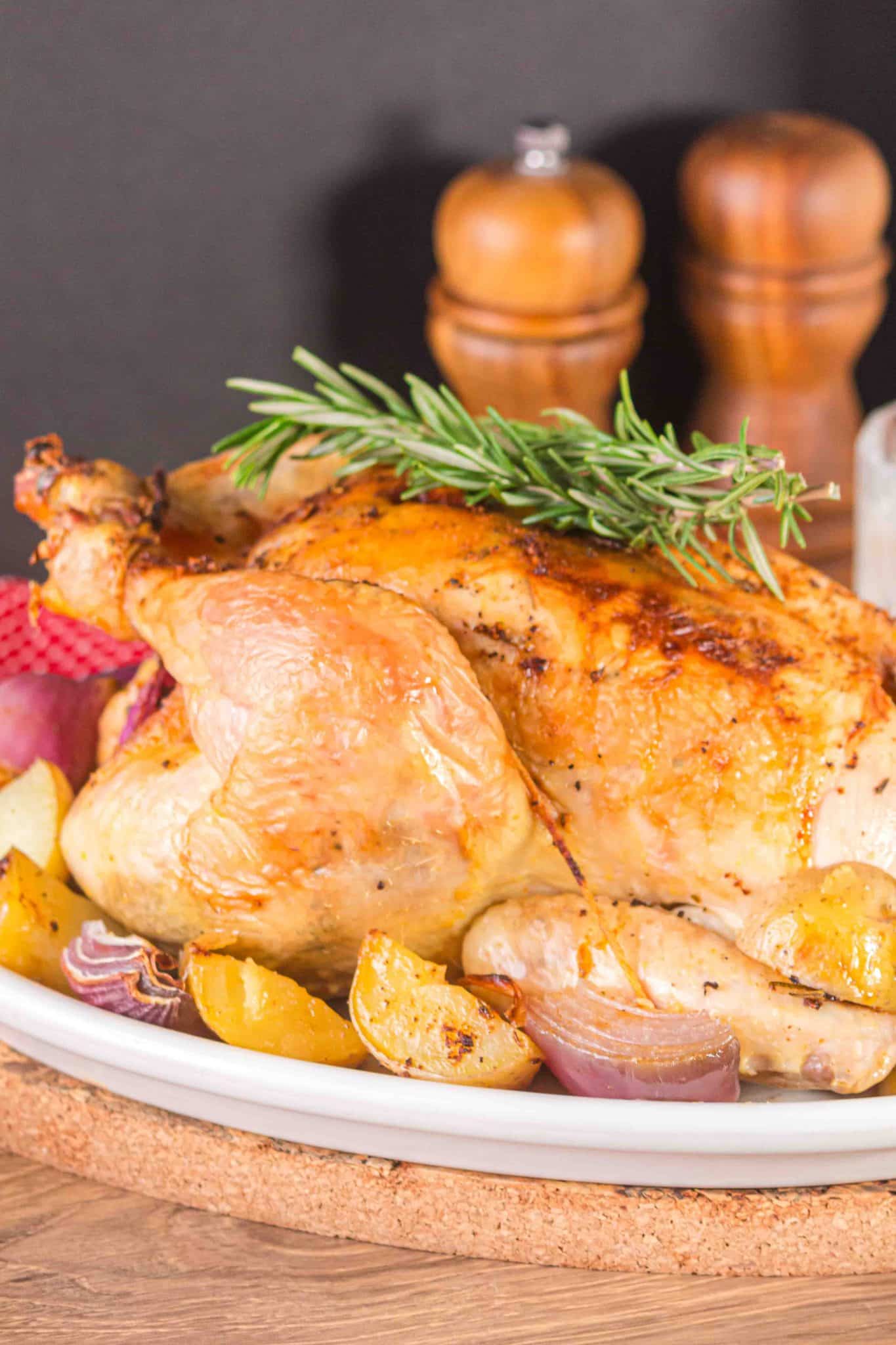Whole roasted chicken and potatoes on a platter.