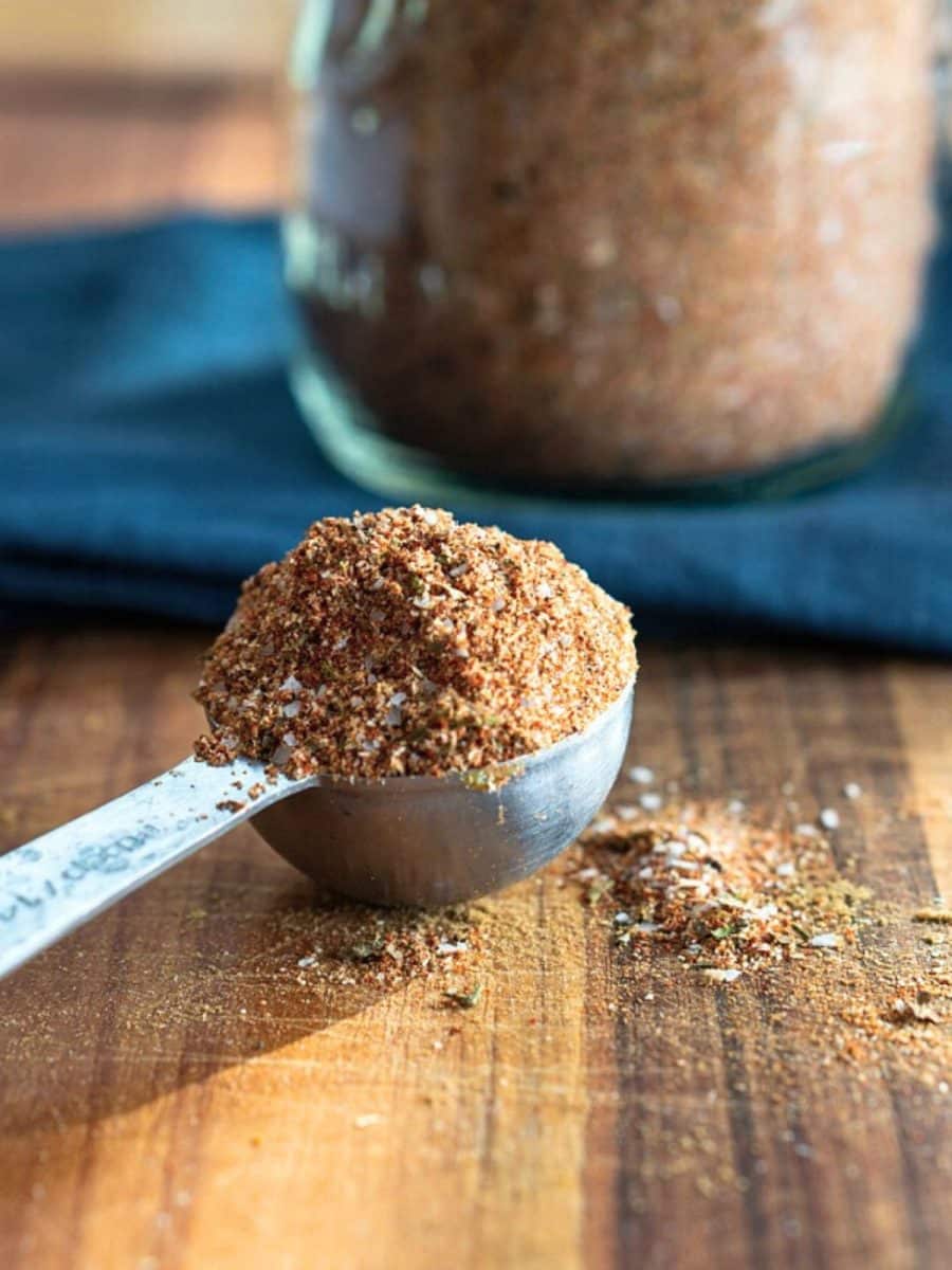 A measuring spoon heaping with homemade creole seasoning. Hostess At Heart