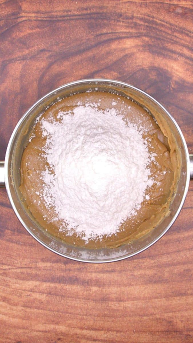 Powdered sugar added to caramel icing in order to make caramel frosting.