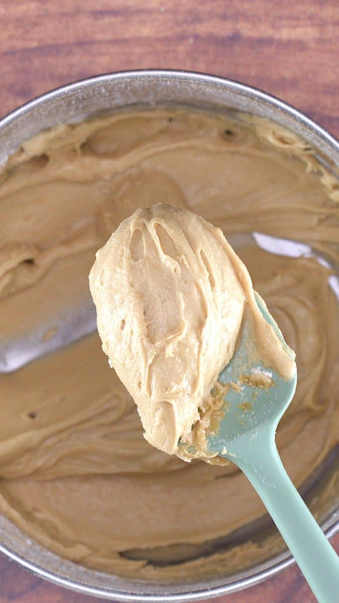 A spatula filled with caramel frosting showing the thick consistency - Hostess At Heart