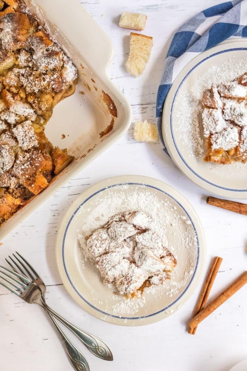 Top down view of two plates of powdered sugar dusted baked French Toast Casserole recipe - Hostess At Heart