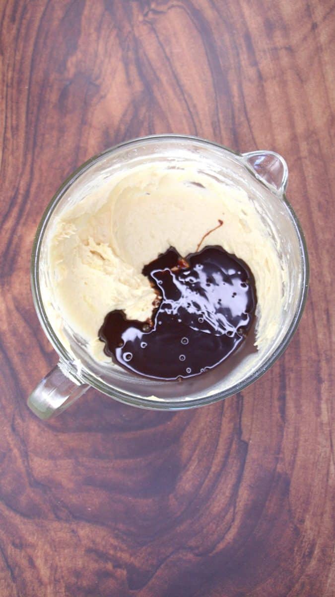 Chocolate syrup added to a bowl of cake batter to make a dark layer - Hostess At Heart