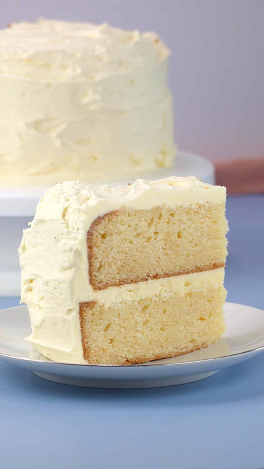 An angled view of a slice of a two layer easy vanilla cake - Hostess At Heart
