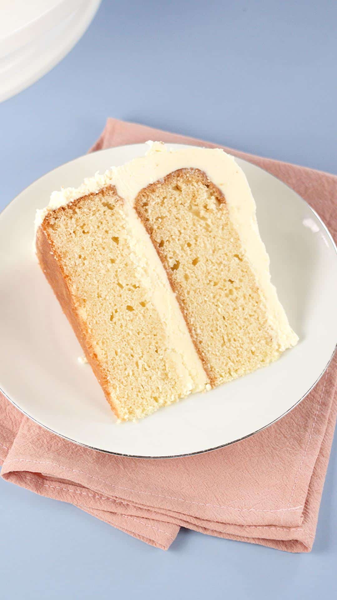 Top down view of The best vanilla cake frosted and laying on it's side. Hostess At Heart