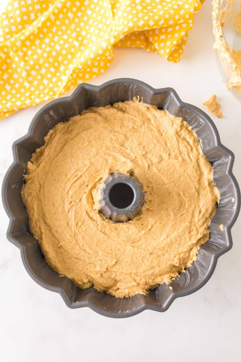 A prepared bundt pan filled 3/4 with cake batter. Hostess At Heart